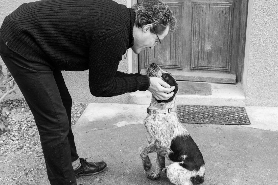 a black and white photo of a person petting a dog