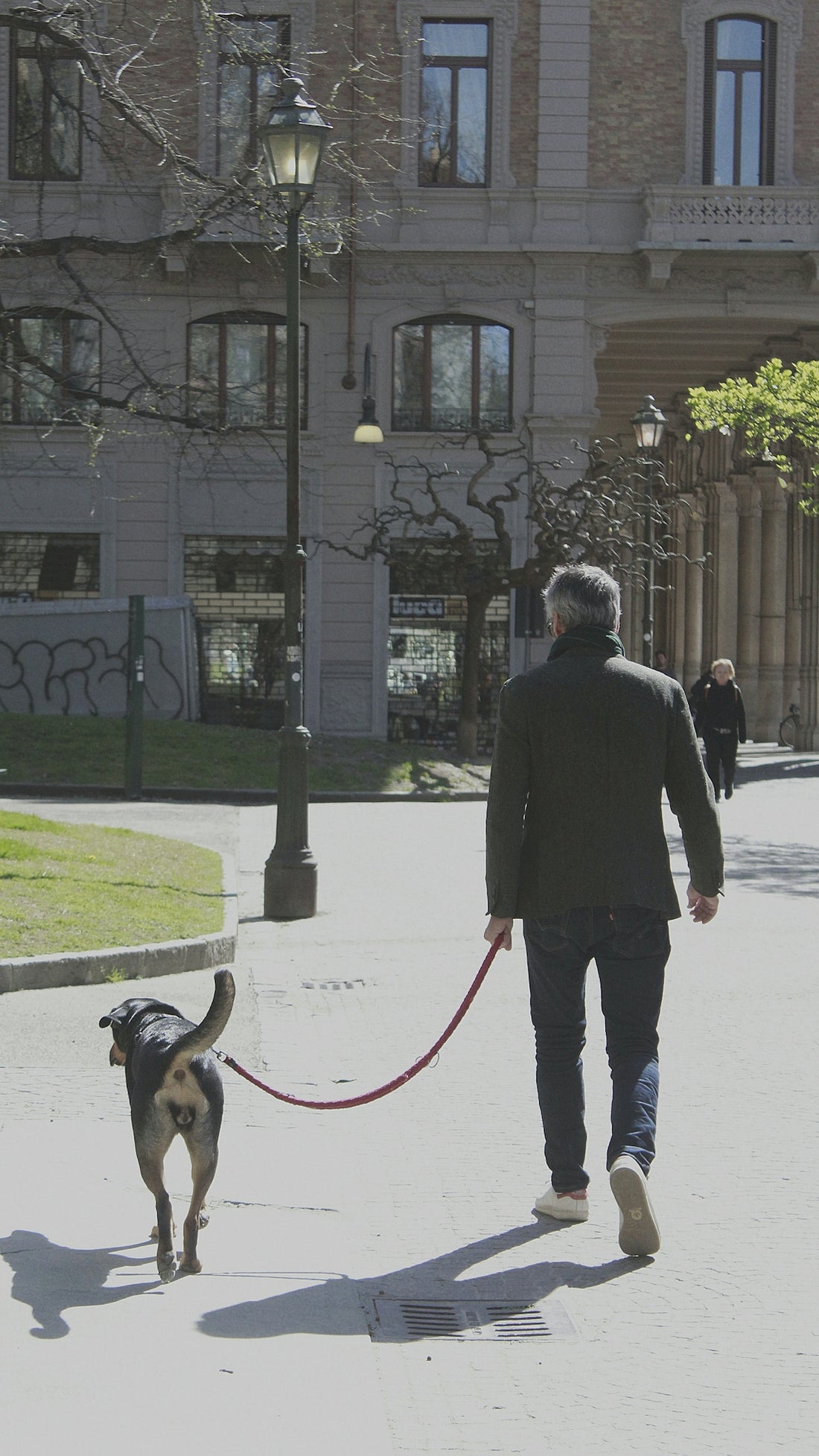 a man walking a dog down a street