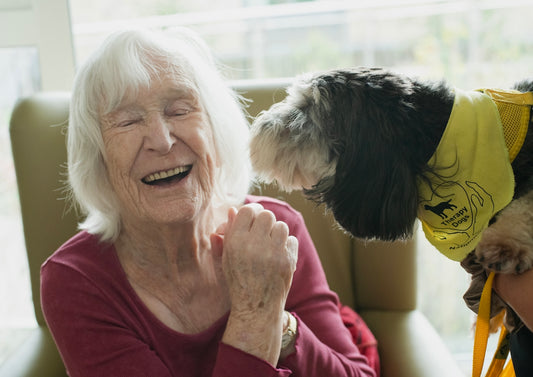 Elderly woman laughing with a dog
